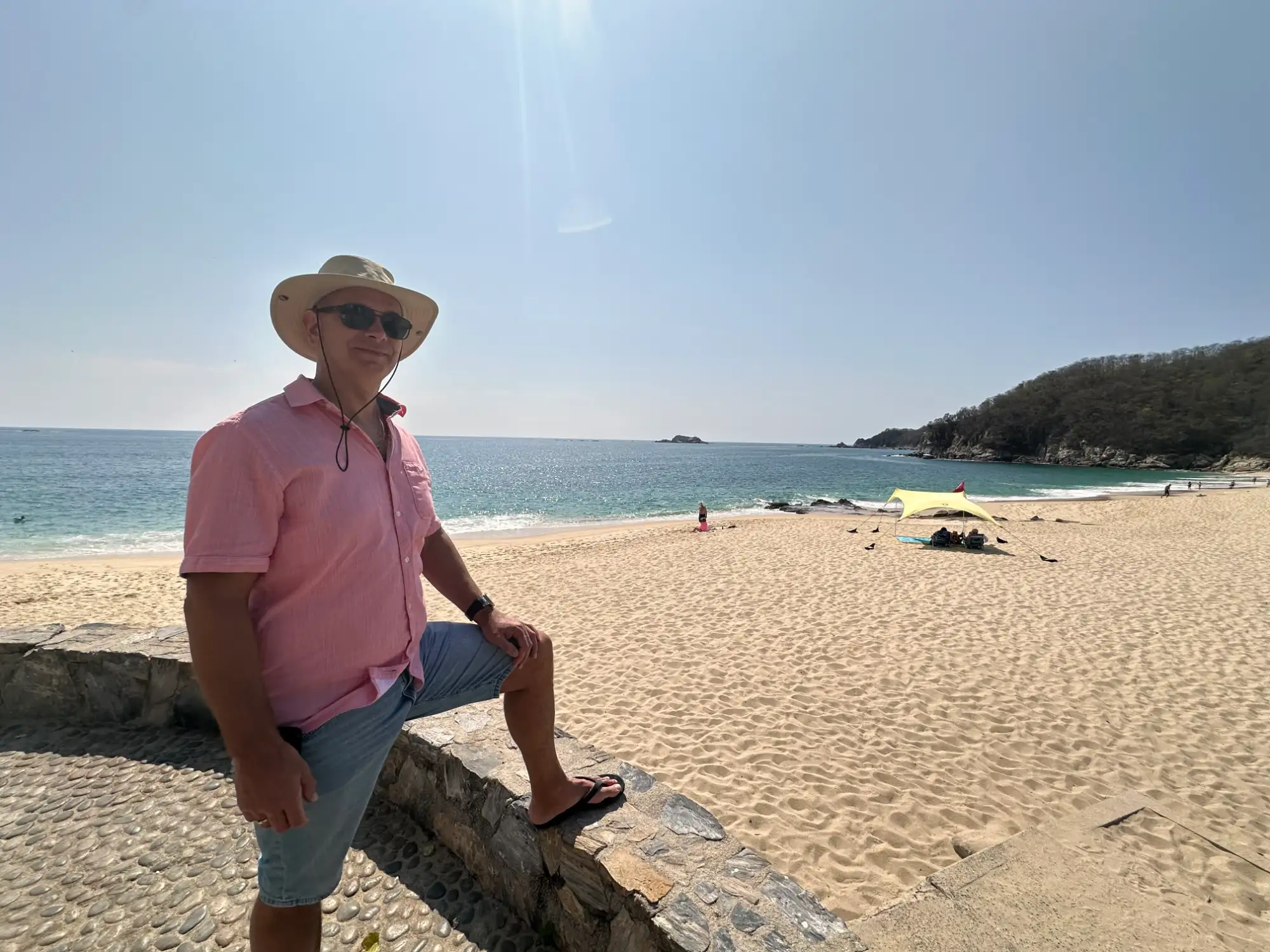 Behind the shades standing beside a beach.