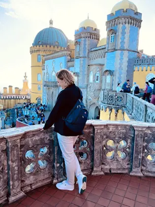 A picture of Irena the founder of Struck by Travel looking out over a balcony at the endless travel possibilities
